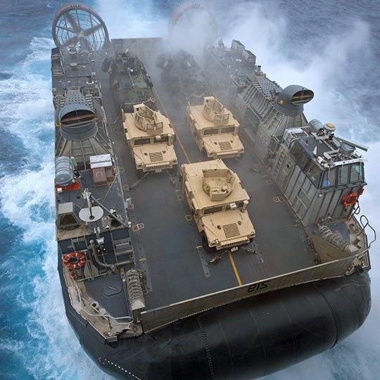 巨型军用气垫船的鸟瞰图，带有移动天线，载着三辆悍马 